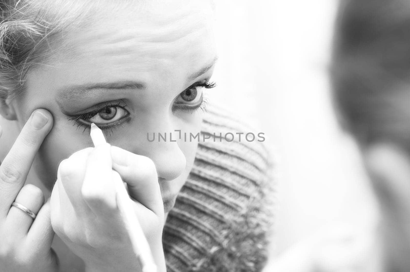 woman applying make up in front of mirror.toned picture