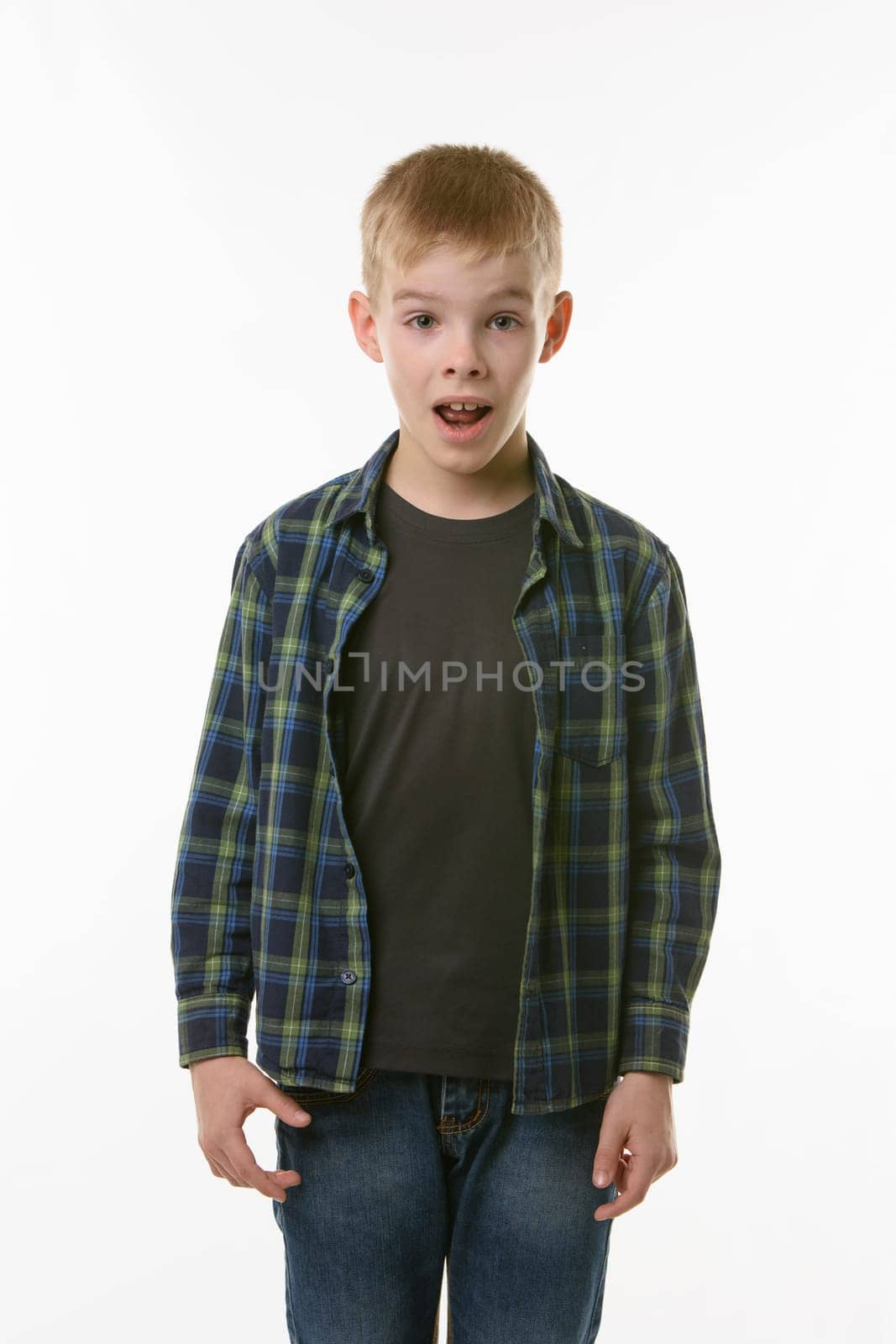 Astonished ten year old boy with open mouth on white background