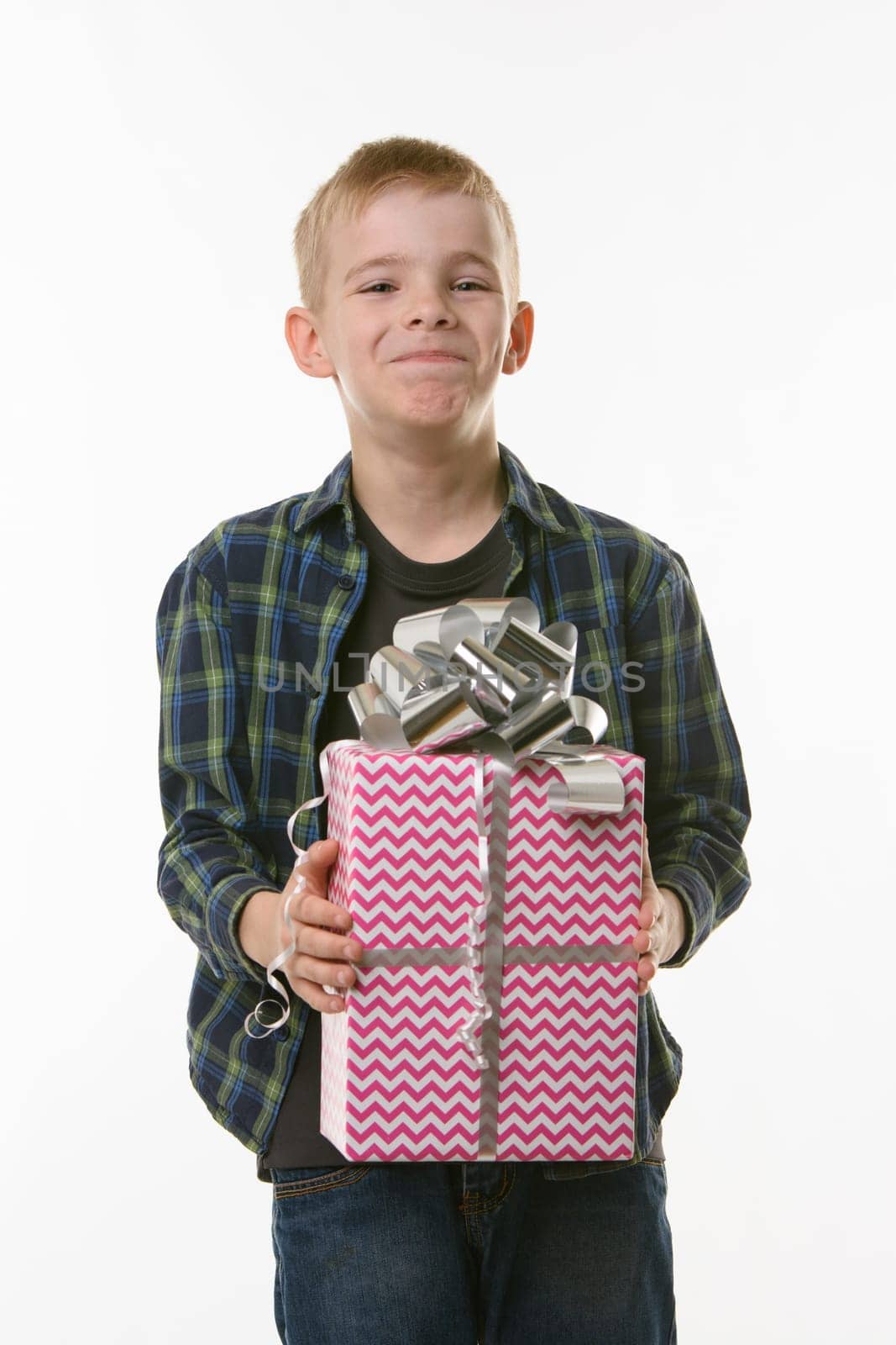 The boy laughs at the present, holding it in his hands