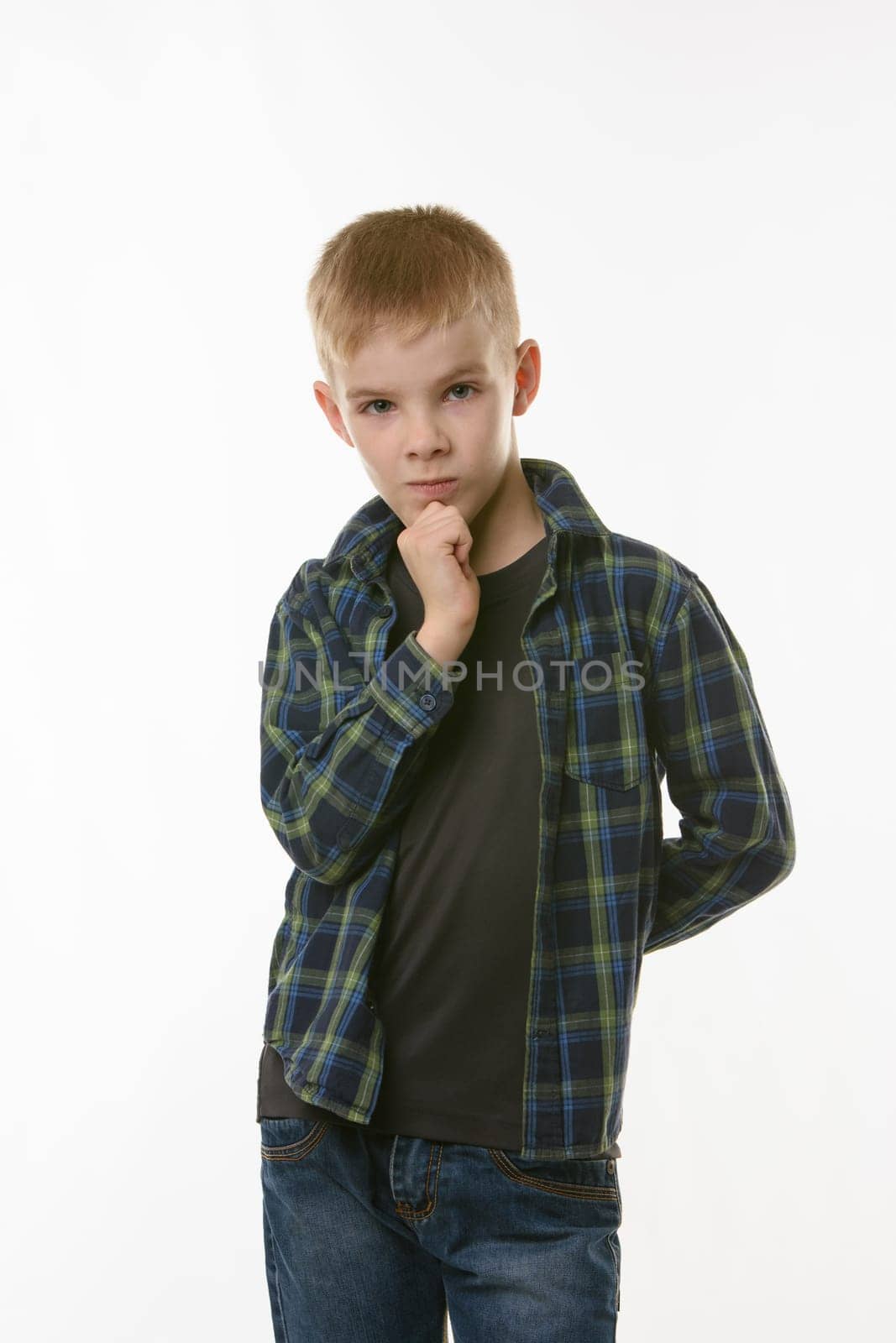 Portrait of a pensive boy in a plaid shirt on a white background