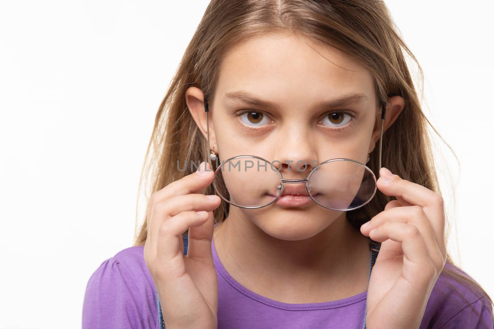 Teen girl takes off glasses, close up