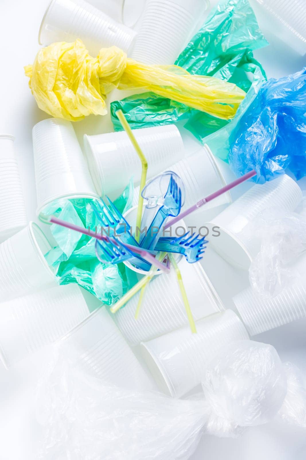 Assortment of disposable plastic, cups, cutlery, bags and drinking straws. Environmental concept. Non-compostable waste
