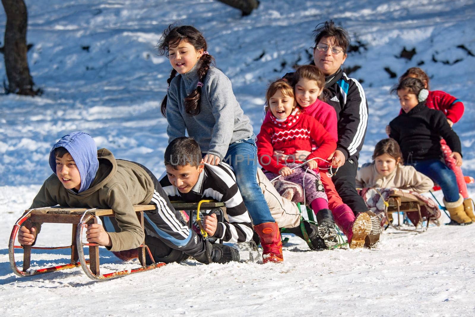 FAGET, CLUJ COUNTY, ROMANIA - FEBRUARY.04.2014: Children from a socially disadvantaged community taken on a vacation trip on a slope to go sledding