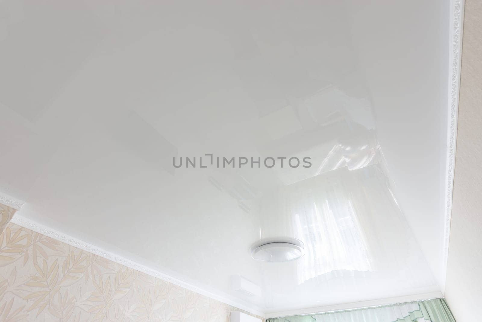 Glossy white ceiling in the interior of the bedroom
