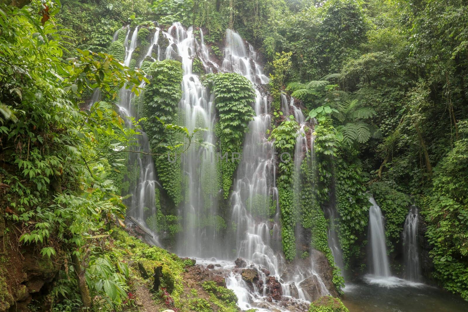 Spray waterfall in Bali island, Indonesia. Scenic waterfall high in the mountains. Having fun in the wild nature. Waterfalls in jungle. Bali Travel Concept. Lifestyle. Travel photography.
