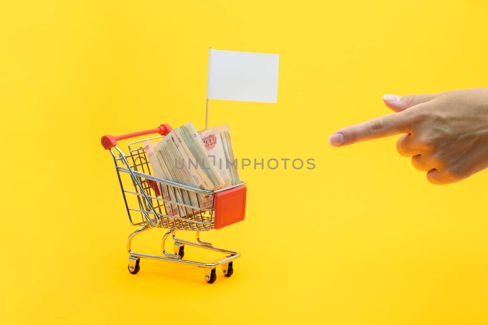 Hand points to a grocery cart with a bundle of notes and a white flag for inscription