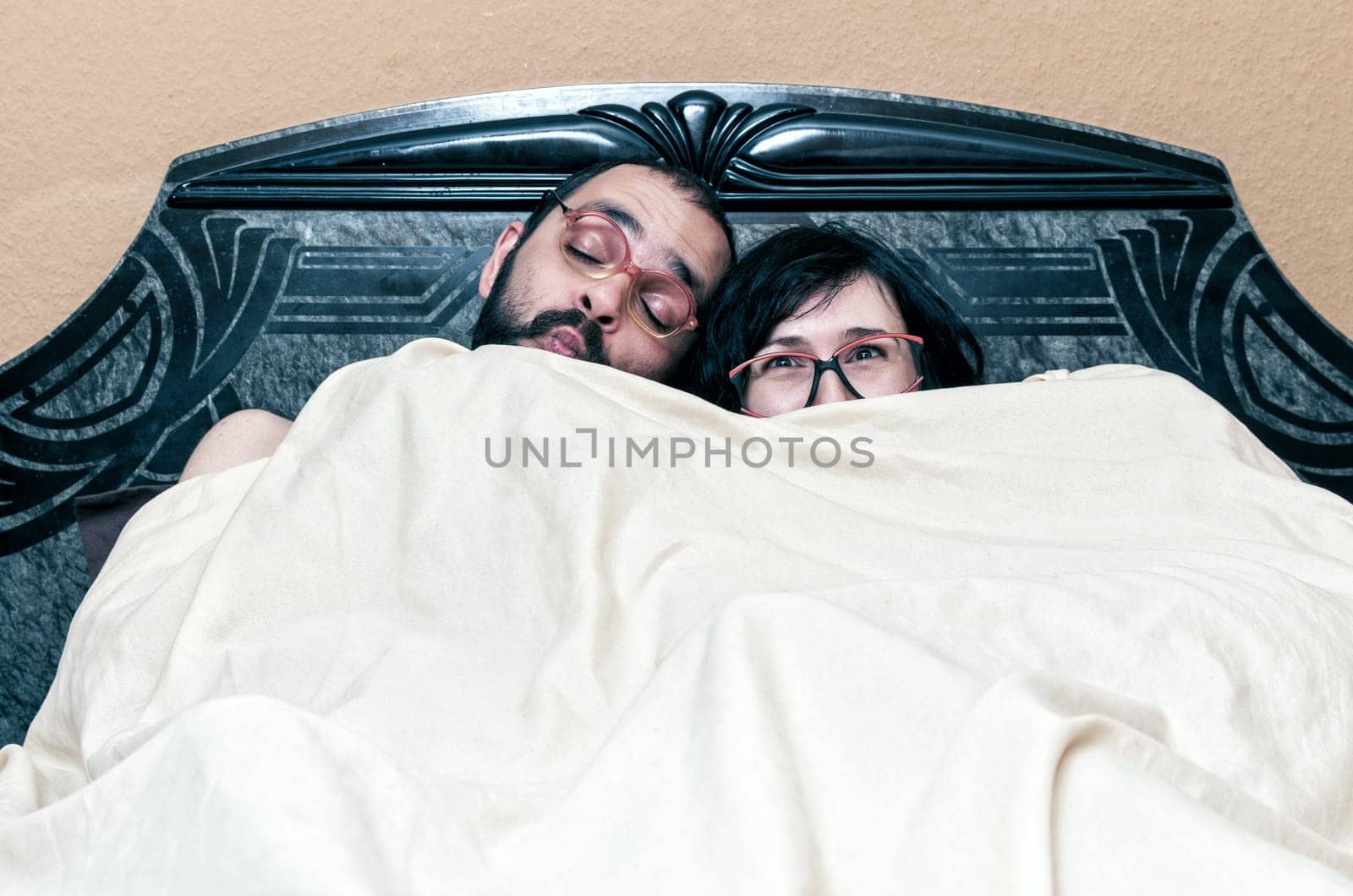 Funny couple with glasses in the bed