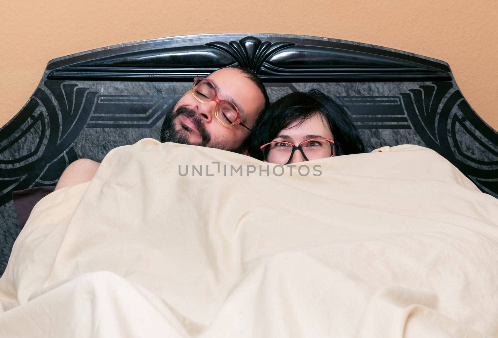 Funny couple with glasses in the bed