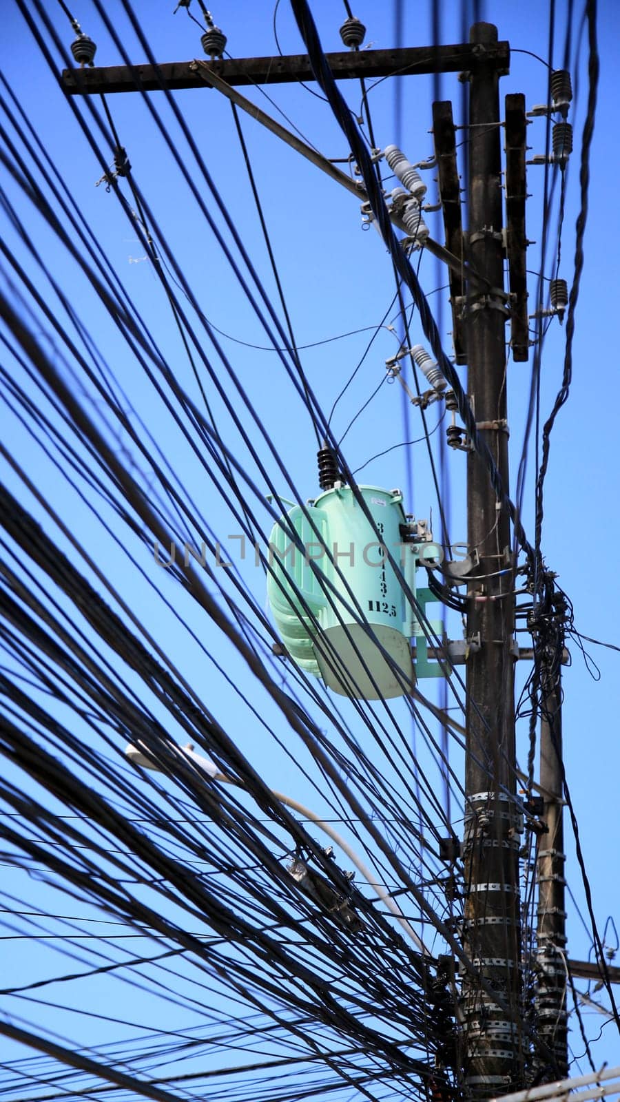 salvador, bahia / brazil - july 1, 2020: electrical network transformer is seen amidst pole wiring in the neighborhood of Pernambues, in the city of Salvador..