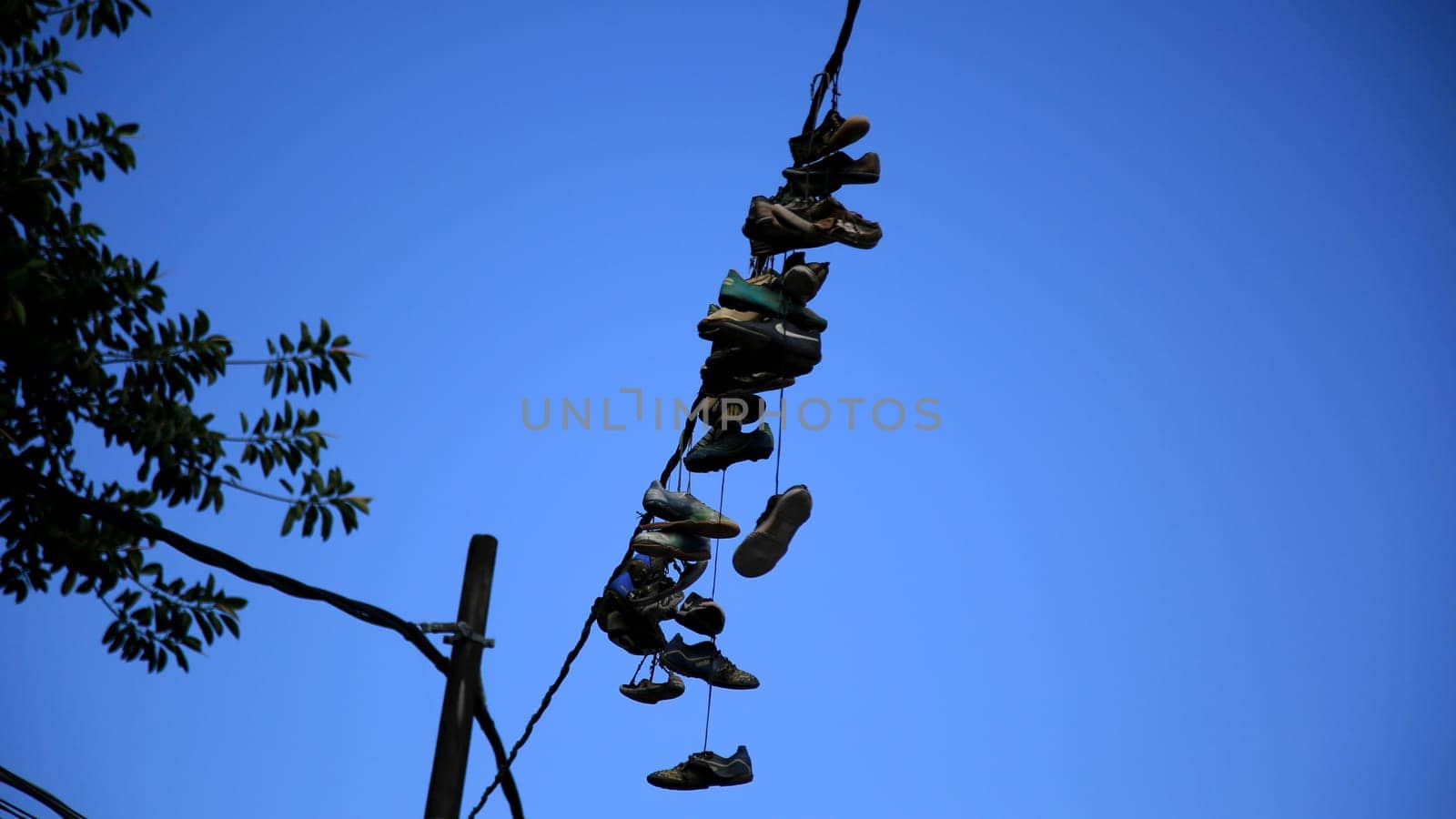 salvador, bahia / brazil - july 1, 2020: shoes are seen hanging from the electrical network's wiring in the neighborhood of Pernambues, in the city of Salvador.