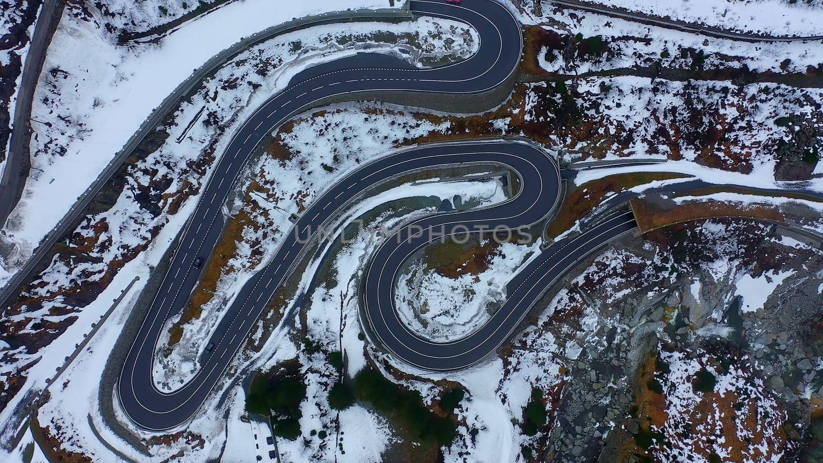 Top down view over a pass street in the Swiss mountains on a winterÂ´s day - aerial photography