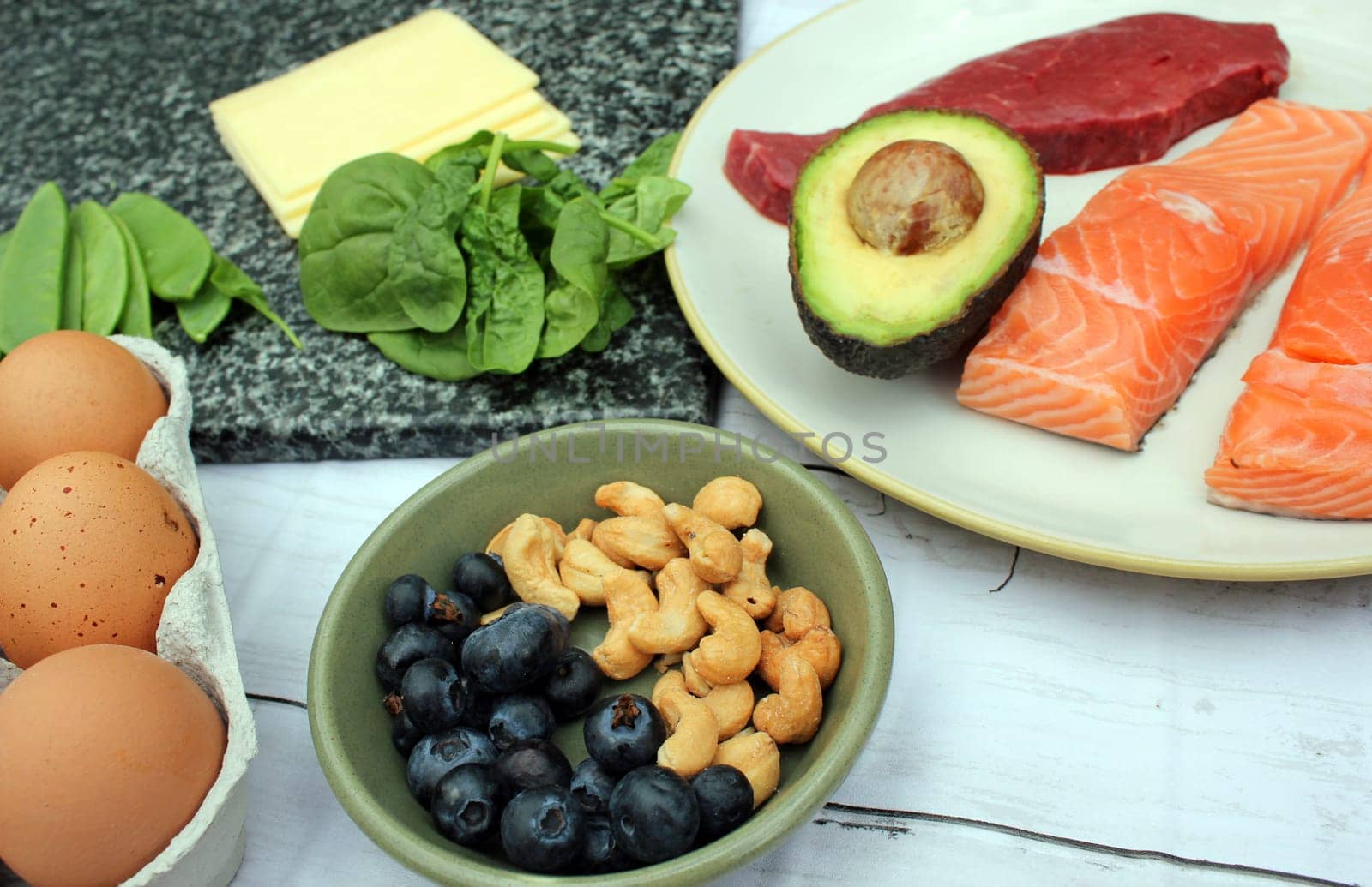 low carb ketogenic gluten free paleo style diet protein based meat fish dairy eggs veg berries and nuts background with copy space