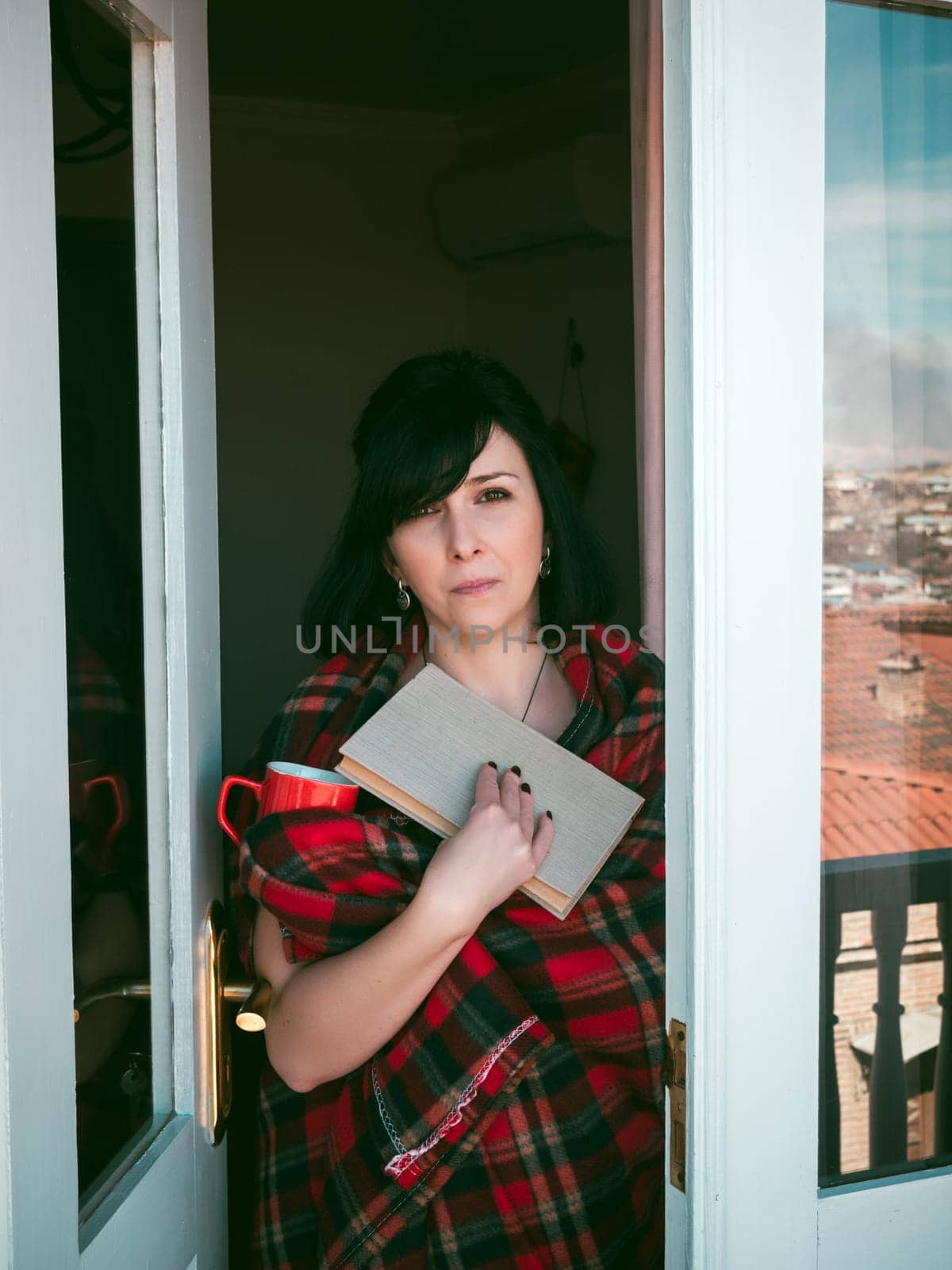 Woman on balcony with book and coffee