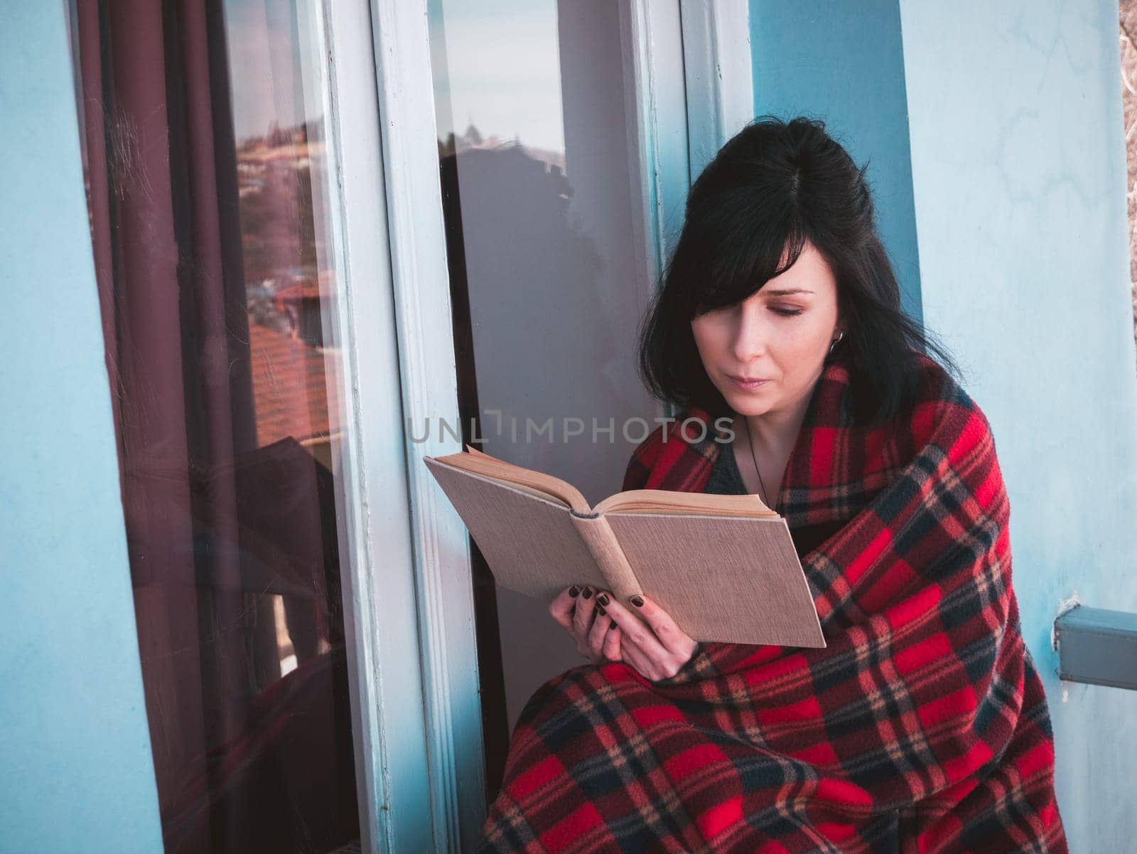 Woman on balcony with book