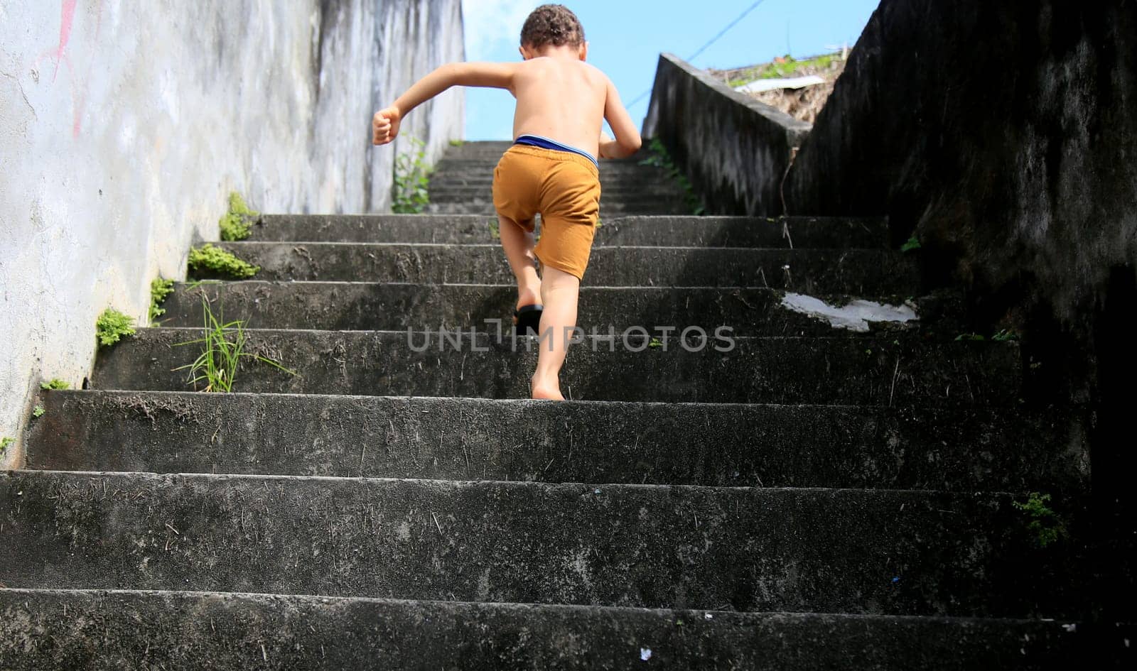 salvador, bahia / brazil - july 2, 2020: child is seen climbing stairs in residential condominium in the city of Salvador.