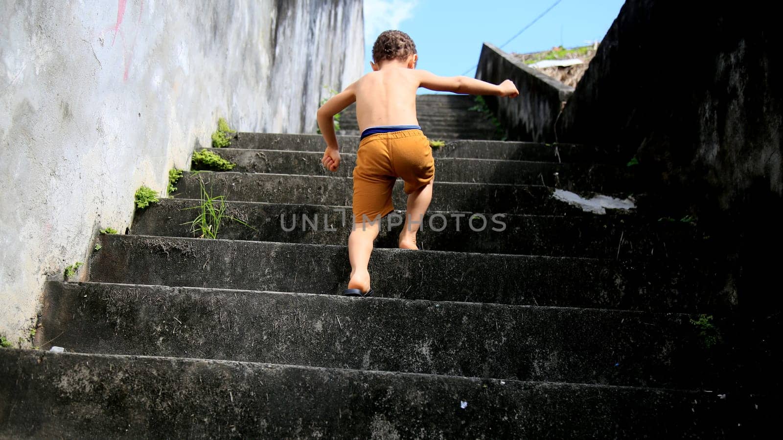 salvador, bahia / brazil - july 2, 2020: child is seen climbing stairs in residential condominium in the city of Salvador.
