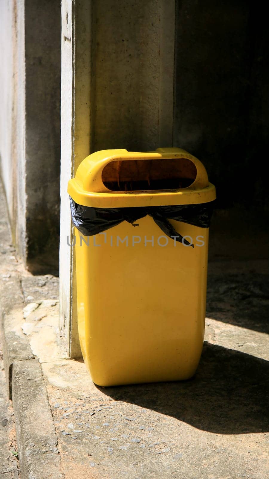 salvador, bahia / brazil - july 2, 2020: yellow trash can is seen in a condominium area in the city of Salvador..