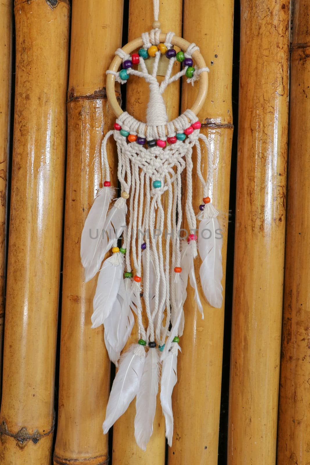 White dreamcatcher - Indian amulet that protects the sleeper from evil spirits and diseases.. The tree - symbol of life. Dream catcher on bamboo background.