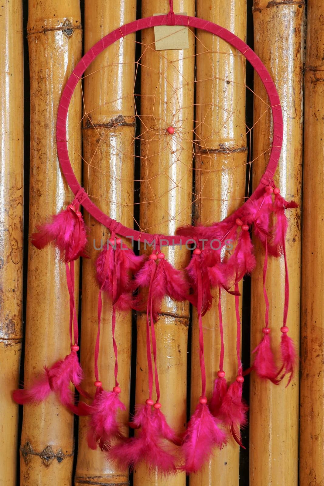 Pink ash crochet doily dream catcher close up on dark gray textured background. Texture of concrete, copy space for text. Wodden background.