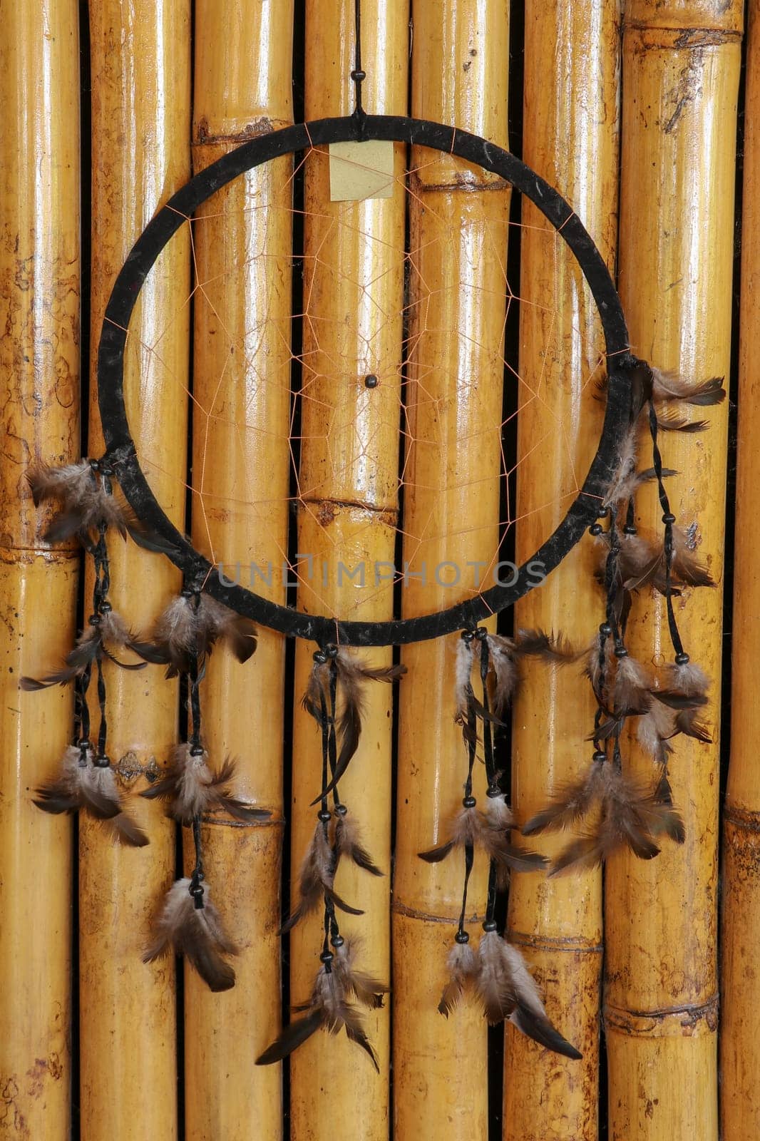 Black dream catcher on bamboo background. Indian amulet.