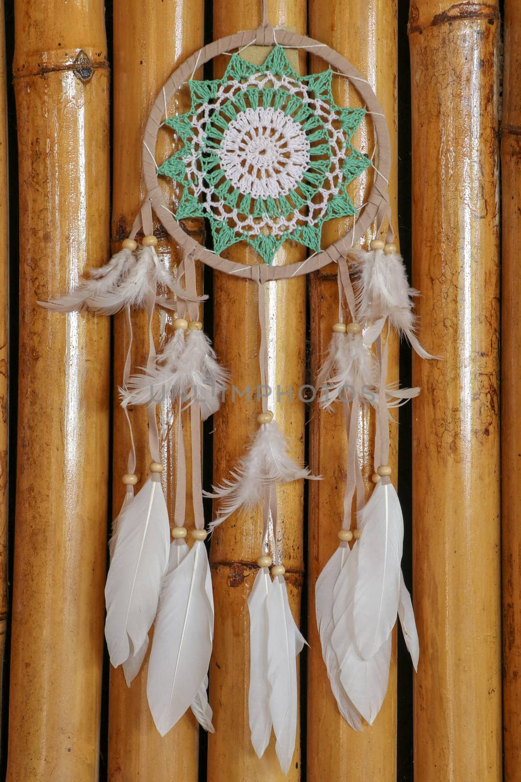 Beautiful green dream catcher on wodden background.