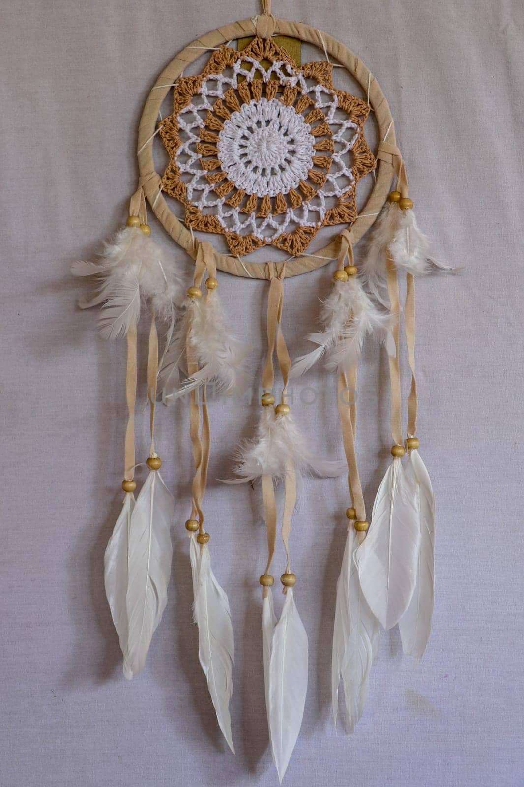 White crocheted dreamcatcher, an Indian amulet that protects the sleeper from evil spirits and diseases. Soft focus. Closeup.