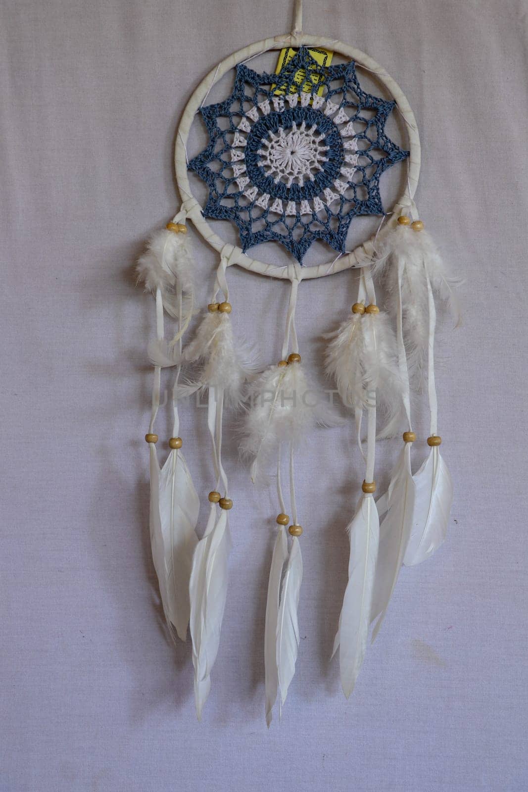 Blue Dreamcatcher with feathers and beads isolated on a white background.
