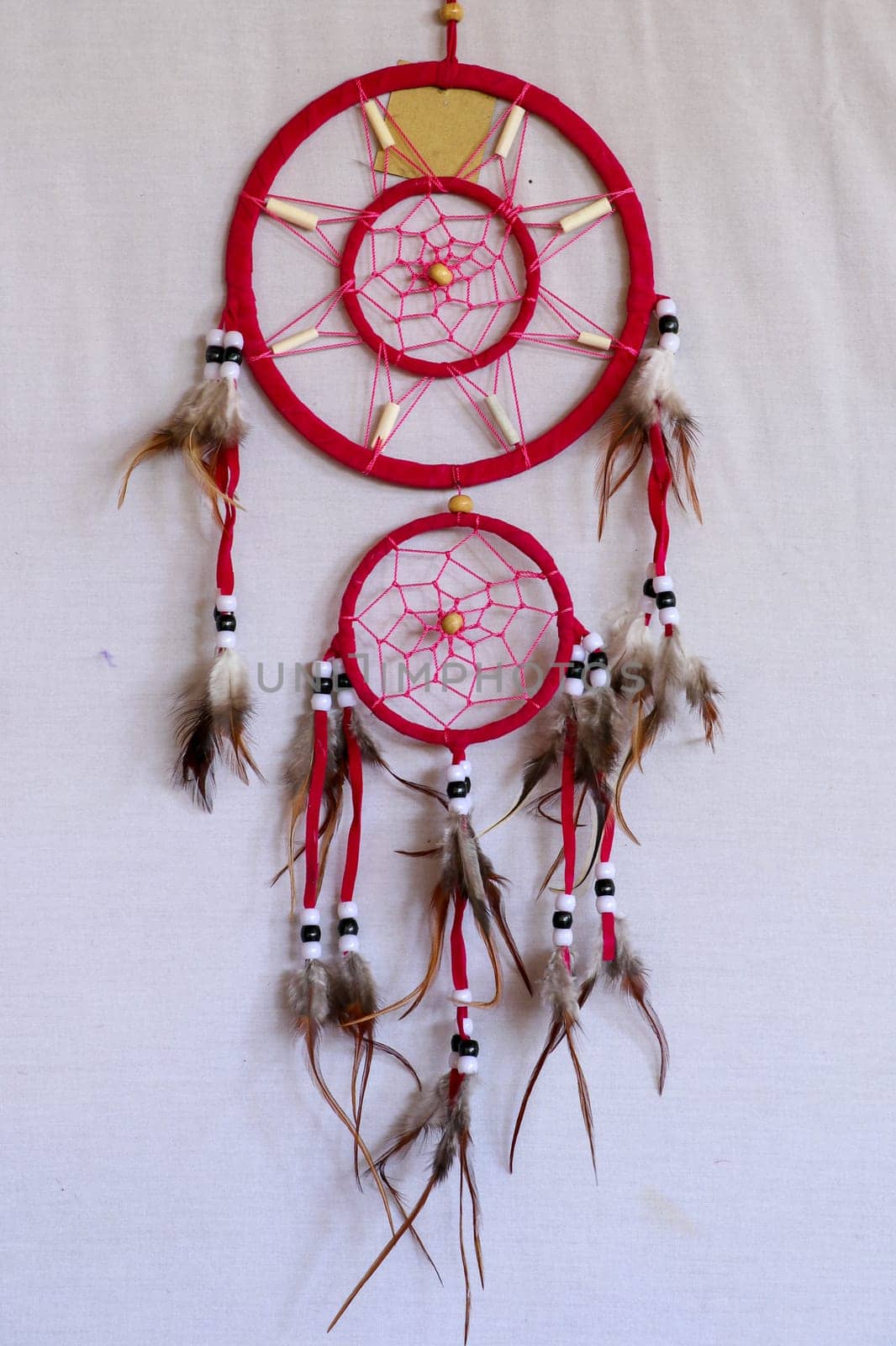 Pink ash crochet doily dream catcher close up on dark gray textured background. Texture of concrete, copy space for text. White background.