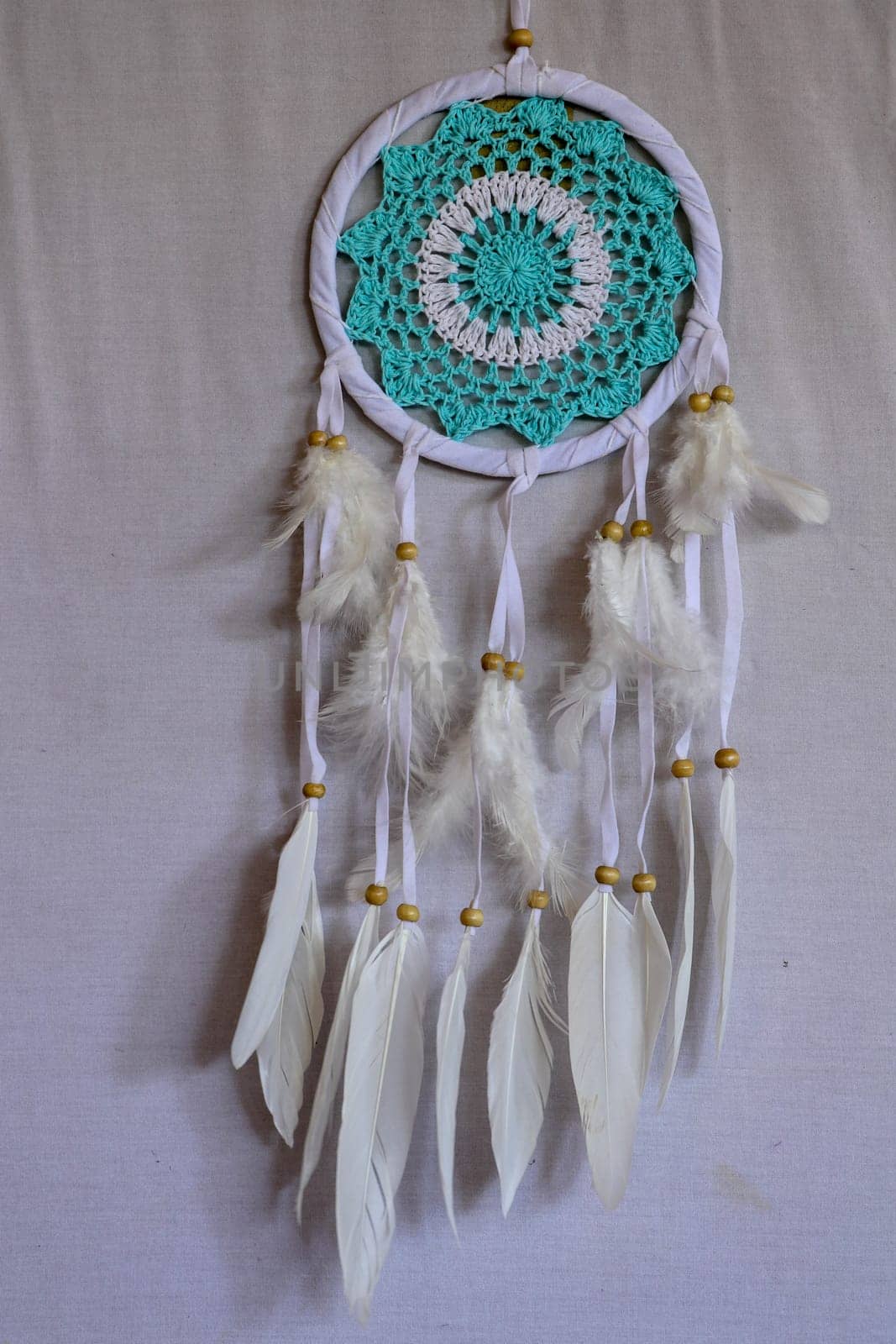 Dream catcher with blue turquoise threads closeup in the interior.