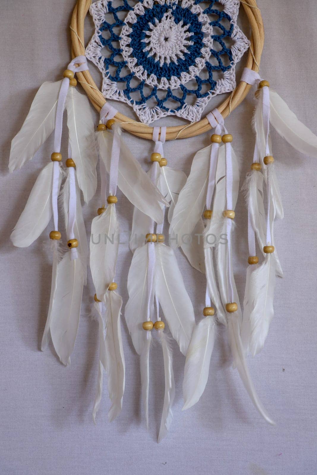 Blue Dreamcatcher with feathers and beads isolated on a white background.
