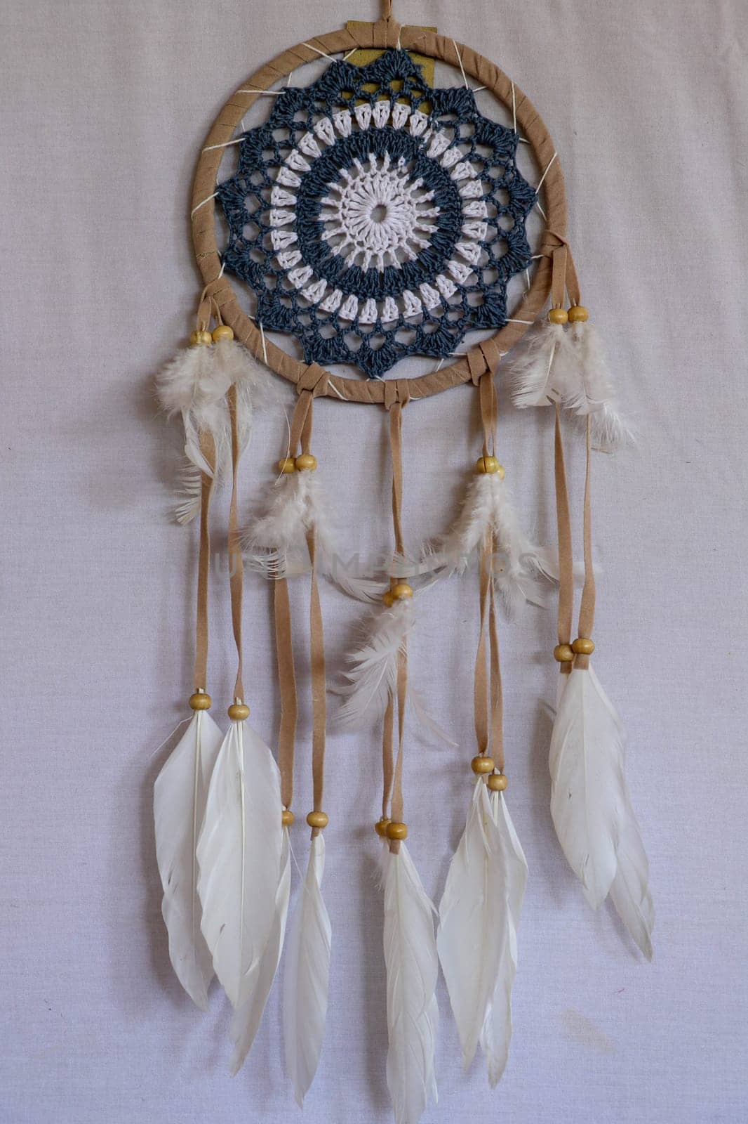Blue Dreamcatcher with feathers and beads isolated on a white background.