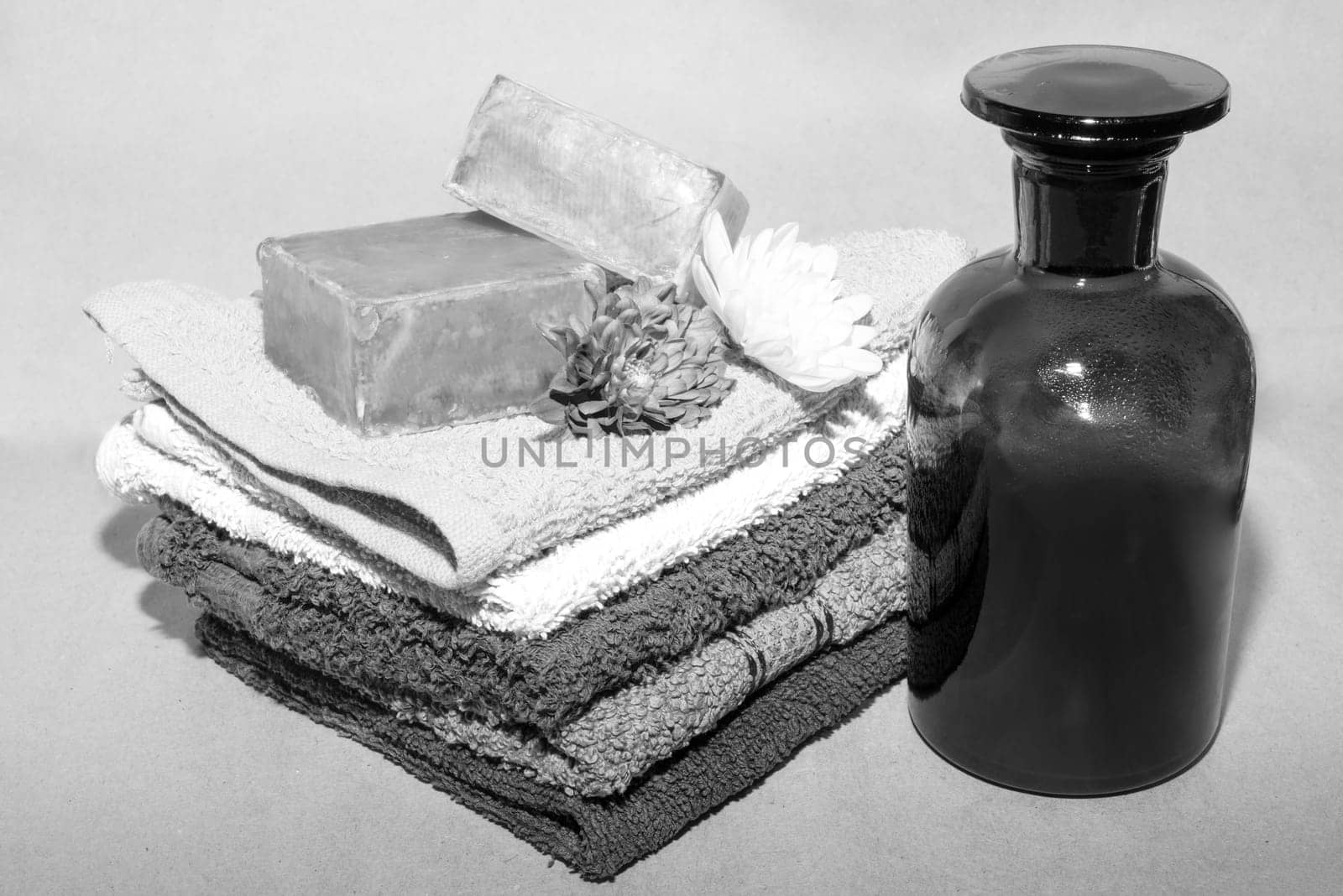 soap bar on top of facecloths off various shades with flowers and bottle