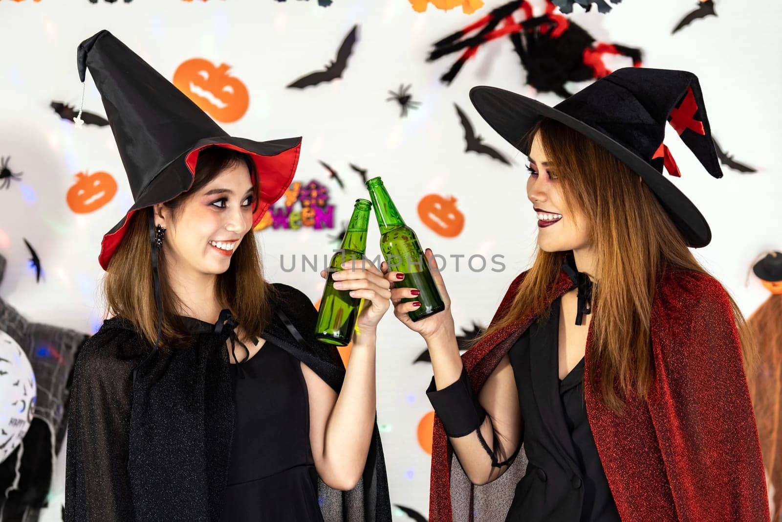 Portrait Asian young adult woman wear halloween costume celebrate a Halloween party carnival Festival and cheers with alcohol beer. Halloween celebrate and international holiday concept.