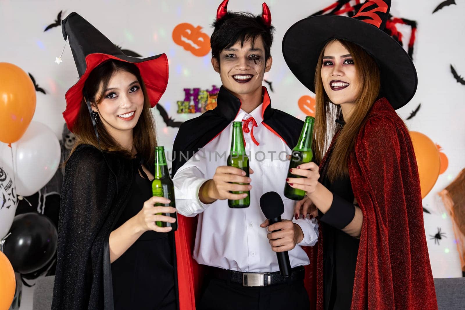 Portrait group of friends asian young adult people celebrate Halloween party carnival festive. They wear Halloween costume sing a song and cheers. Halloween celebrate and international holiday concept