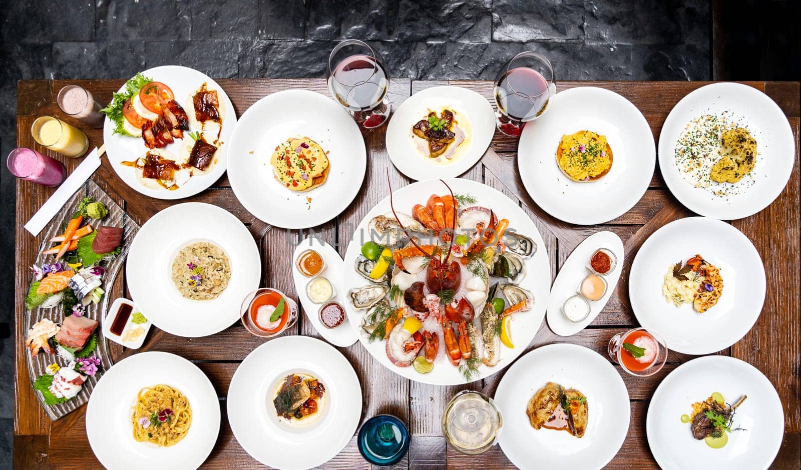 Table top view premium variety of international food in restaurant of lobster shrimp steak beef lamb pasta spaghetti risotto rice sushi sashimi and wine using for buffet food drink background.