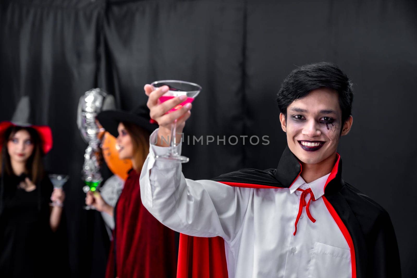 Portrait of asian young adult teenage man wear Halloween costume cloth with group of friends in Halloween party background. Halloween celebrate and international holiday concept.