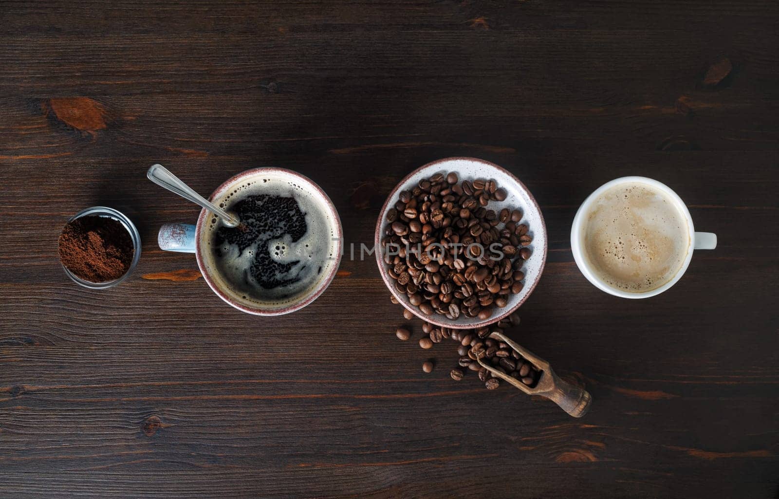 Espresso, coffee cup, coffee beans and ground powder on wood table background. Top view. Flat lay.