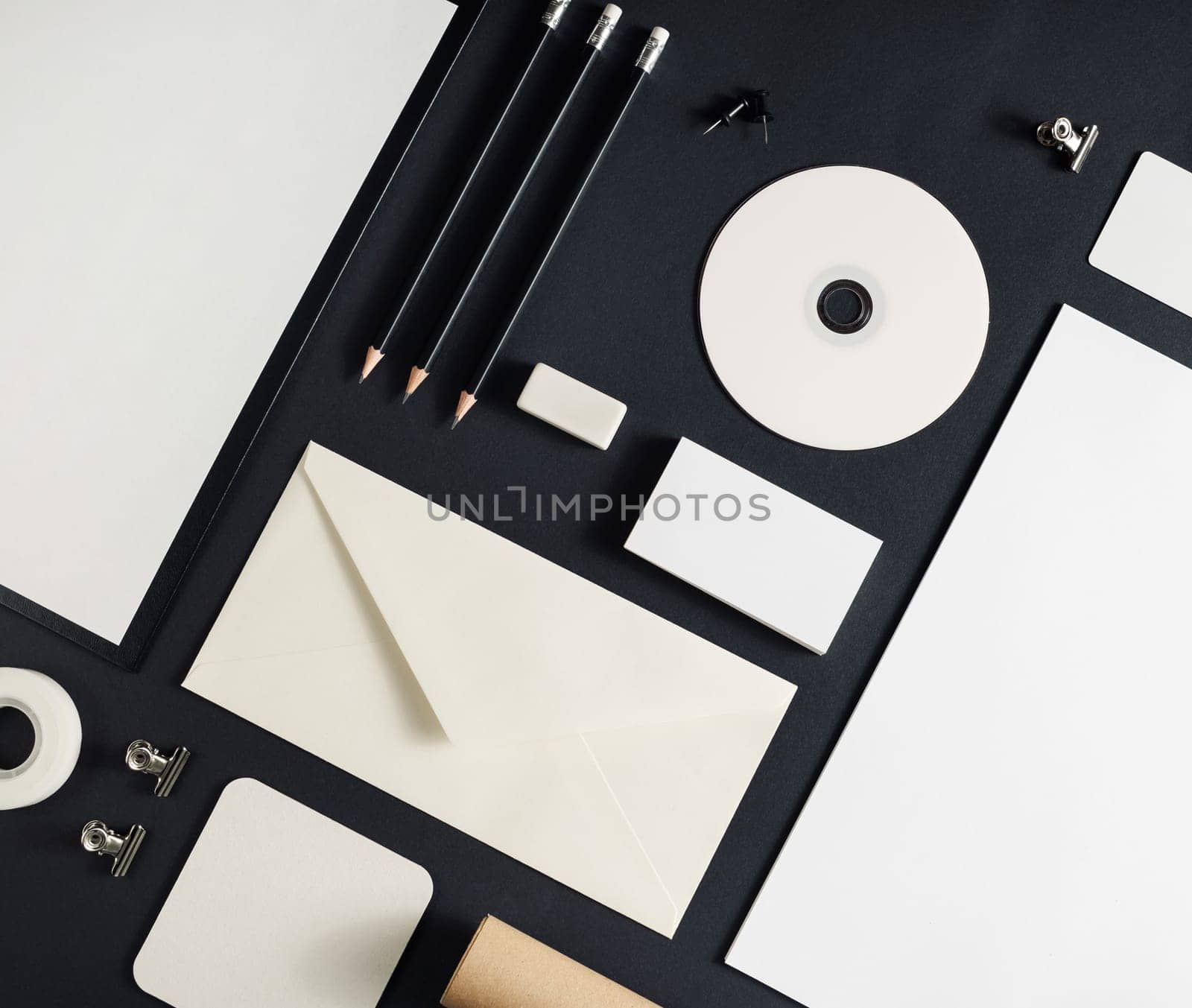 Photo of blank stationery set on black paper background. Corporate identity template. Responsive design mockup. Flat lay.