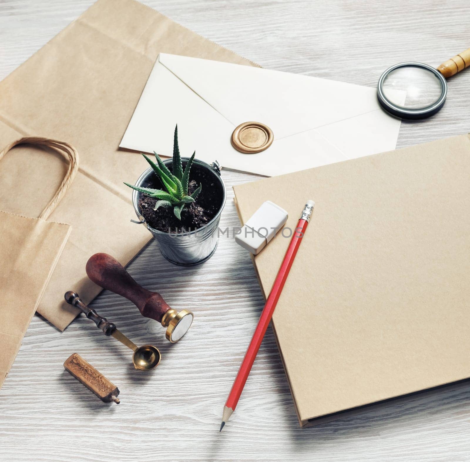 Envelope and retro stationery set on light wood table background. Responsive design mockup.