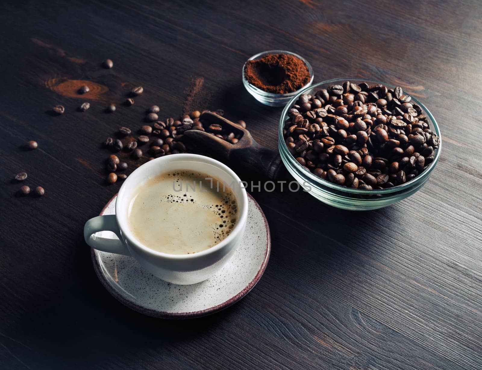 Hot coffee cup with coffee beans roating on wooden table and background.