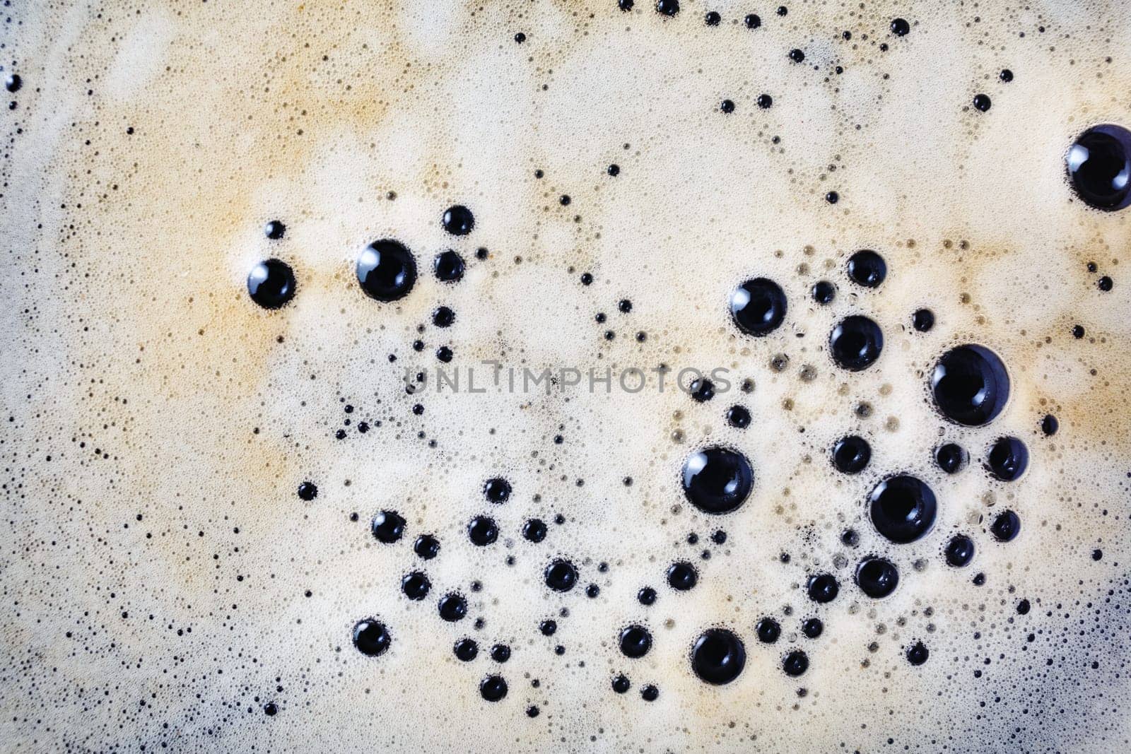 Coffee foam with bubbles background. Close-up coffee texture. Top view. Flat lay.
