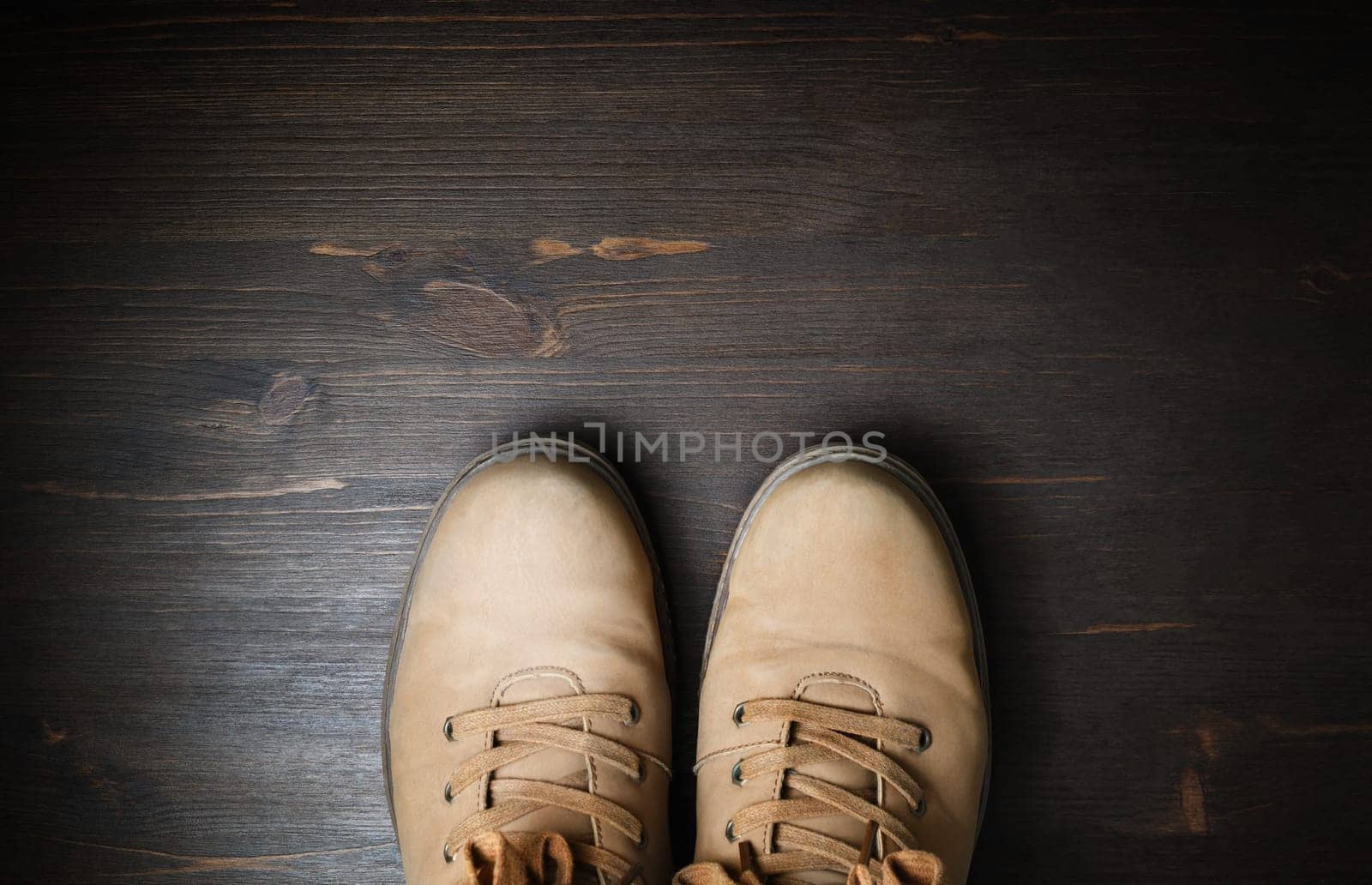 Shoes for travel. Travel boots on brown wood floor background. Copy space for your text. Flat lay.