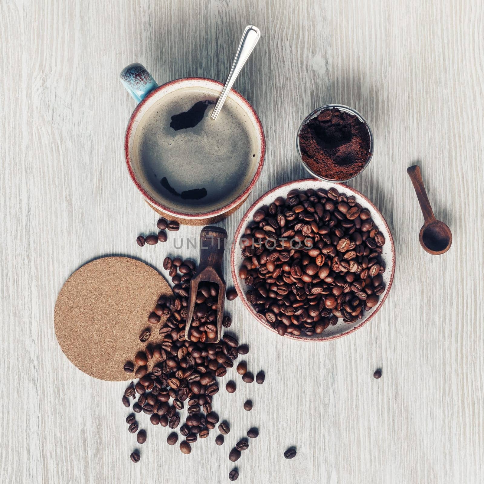 Making coffee still life. Coffee cup, roasted coffee beans, ground powder and beer coaster. Flat lay.