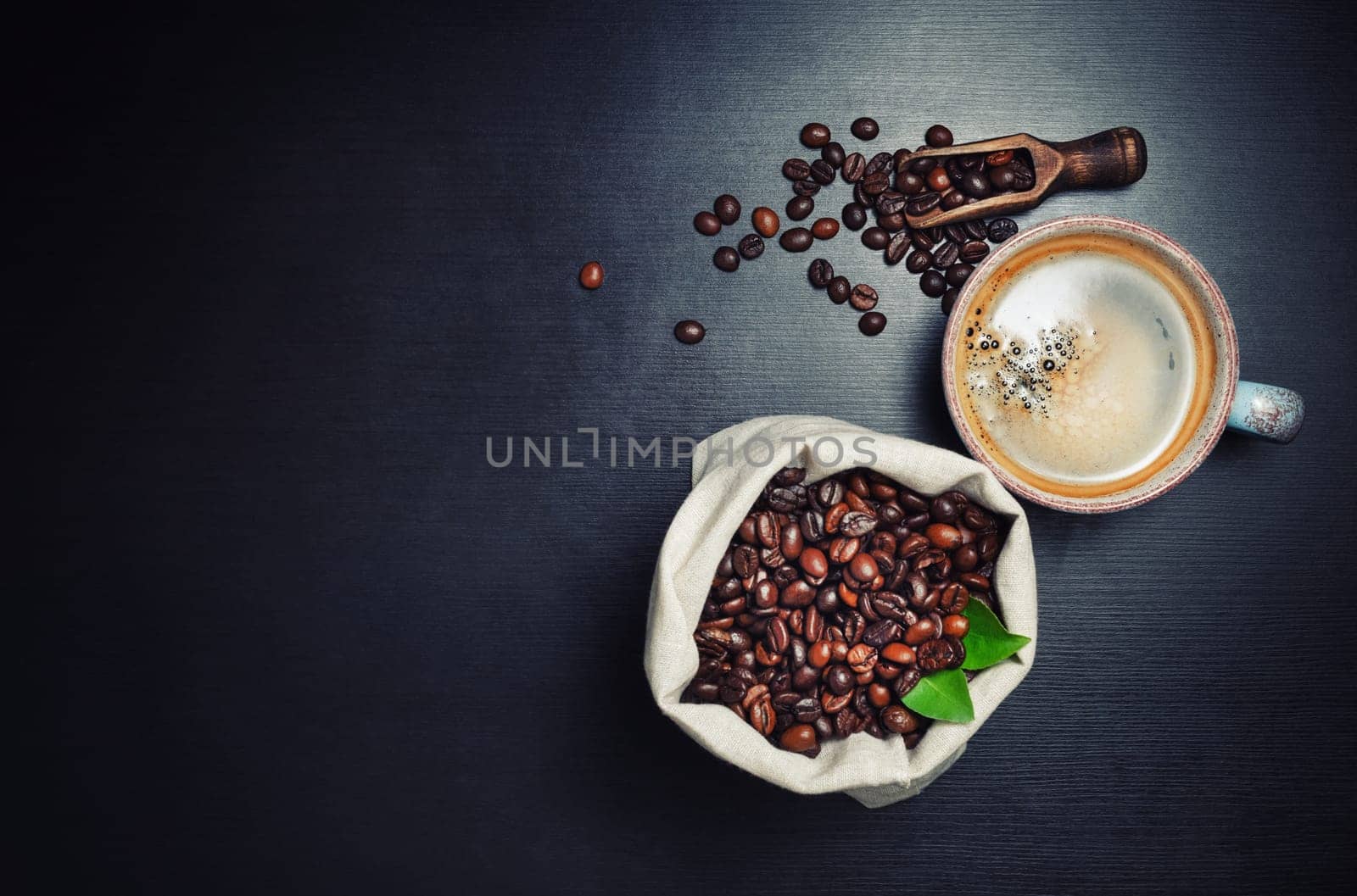 Hot coffee cup and coffee beans on black kitchen table background. Lot of copy space for your text. Top view. Flat lay.