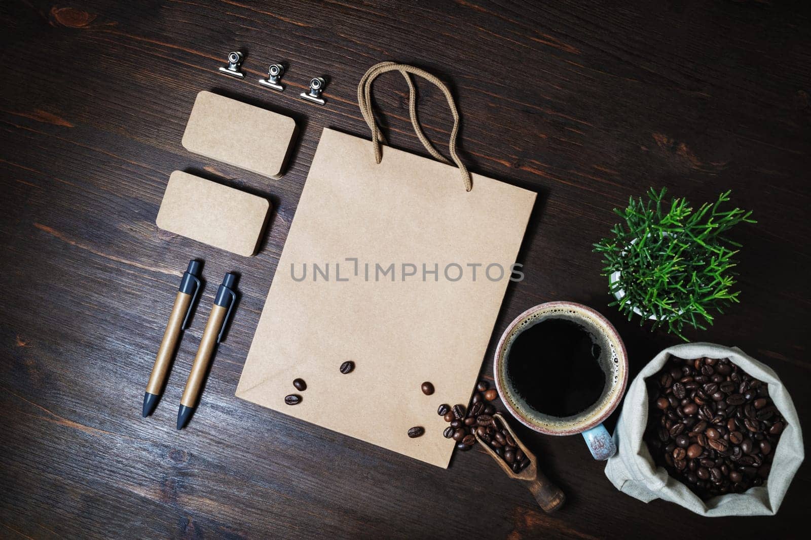 Vintage kraft stationery set and coffee on wood kitchen table background. Flat lay.