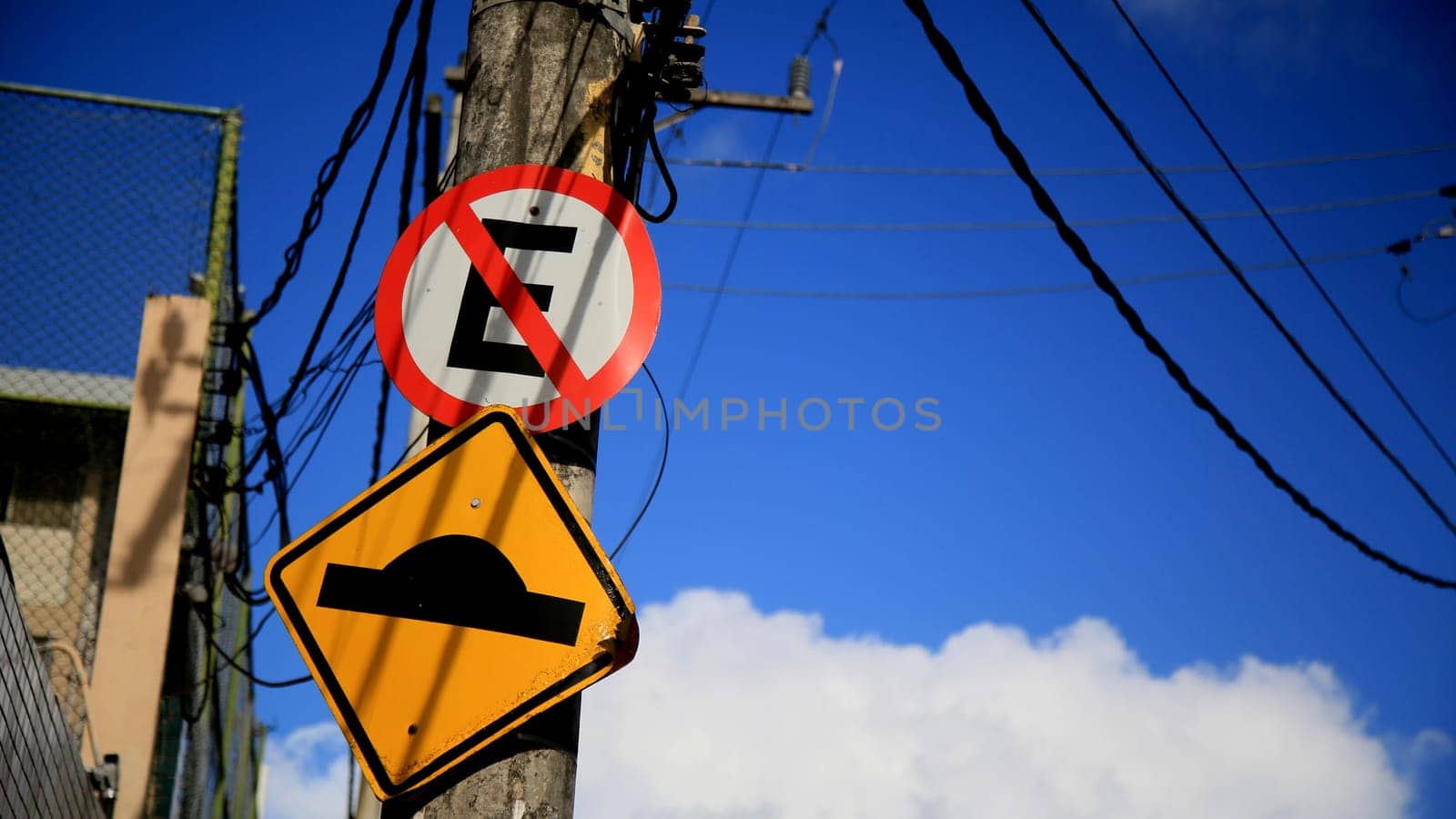 salvador, bahia / brazil - july 4, 2020: traffic signs indicate speed bumps and forbidden to park on a pole attached to the electricity grid in the Cabula neighborhood in the city of Salvador..