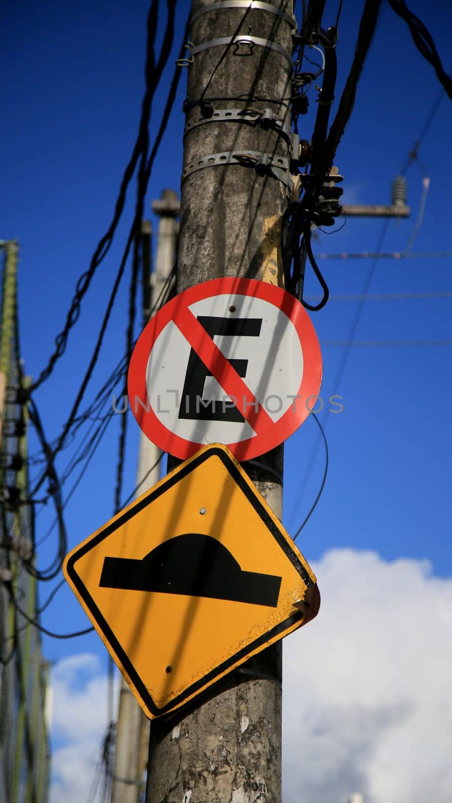 salvador, bahia / brazil - july 4, 2020: traffic signs indicate speed bumps and forbidden to park on a pole attached to the electricity grid in the Cabula neighborhood in the city of Salvador..