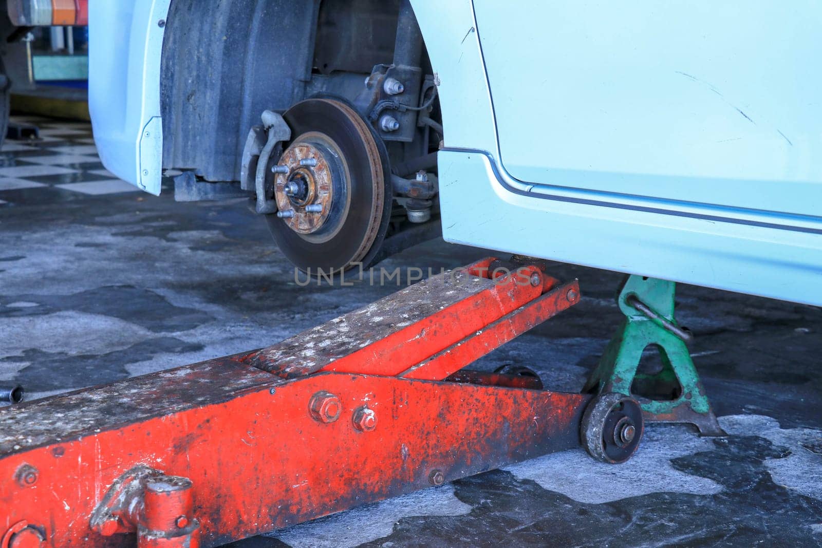 Replacing wheels on a car, jack holds the body in raised position.