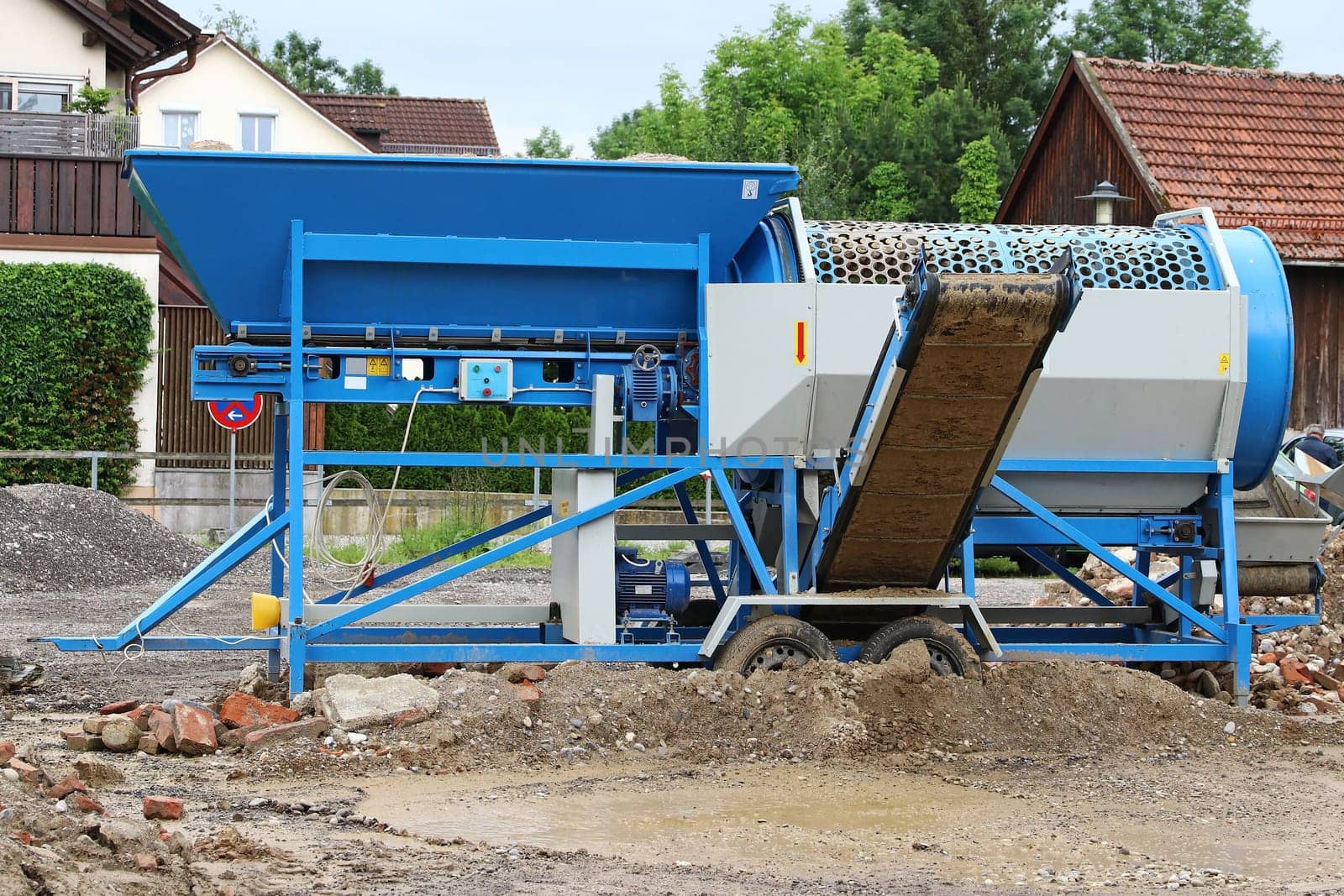 A mobile stone crusher or building rubble shredder for crushing construction material, stones and bricks