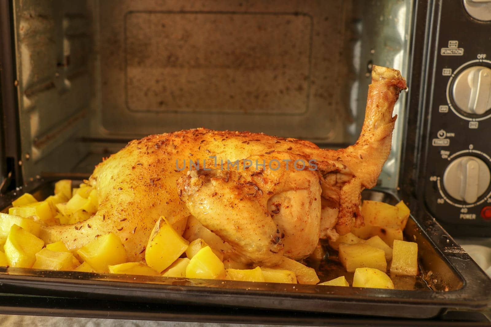 Oven-baked chicken with vegetables and herbs. Symbolic image. Rustic food. Home made food. Concept for a tasty and hearty meal. Rustic wooden background.